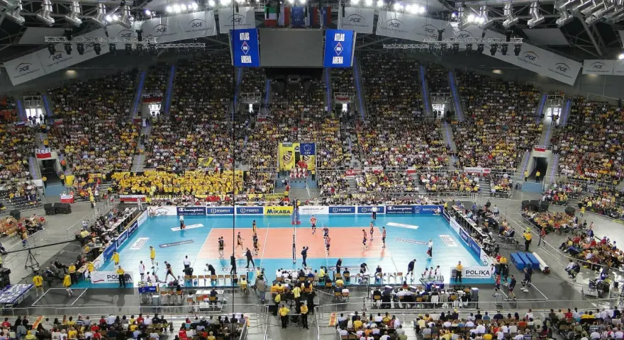 Widok na pełną trybunę Atlas Arena podczas meczu siatkówki. Tysiące kibiców w żółtych barwach tworzy gorącą atmosferę.