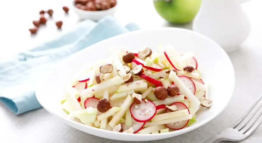Frischer Kohlrabi Salat mit Radieschen und Haselnüssen, garniert mit Apfelstücken. Ein leichter Genuss!
