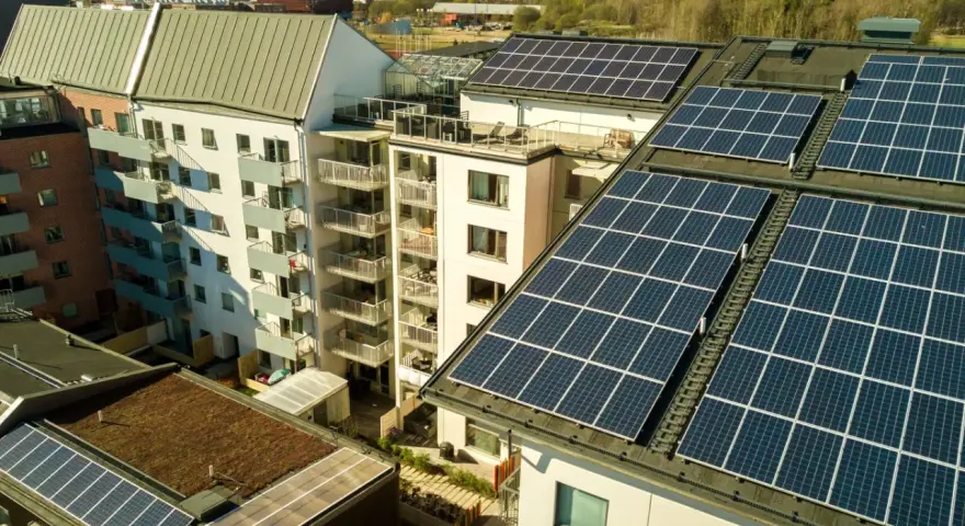 Dachy budynków mieszkalnych pokryte panelami słonecznymi. Mieszkańcy są prosumentami lokatorskimi, czerpiąc energię ze słońca.