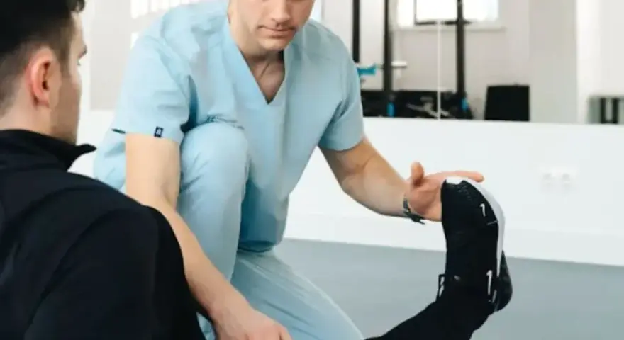 Fizjoterapeuta sportowy pomaga pacjentowi w ćwiczeniach. Zastanawiasz się, ile zarabia fizjoterapeuta sportowy?