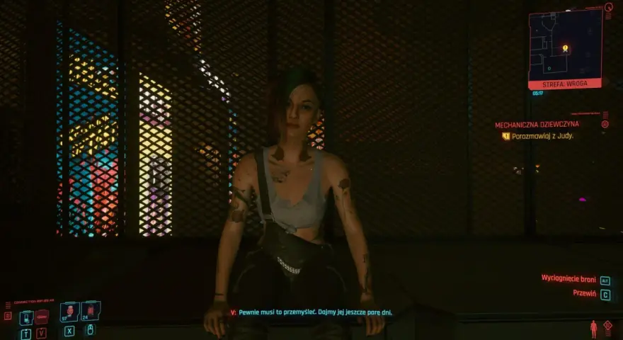 Dziewczyna w stylu czarne czy czerwone cyberpunk, z tatuażami i zielonymi włosami, siedzi na tle neonowych świateł.