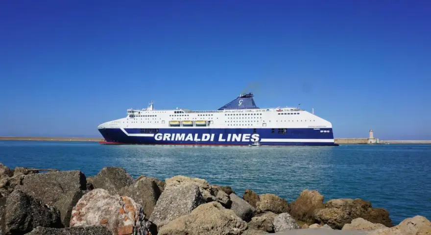 Prom Grimaldi Lines wypływa z Livorno do Palermo. Statek "Cruise Sardegna" na tle błękitnego nieba i morza.