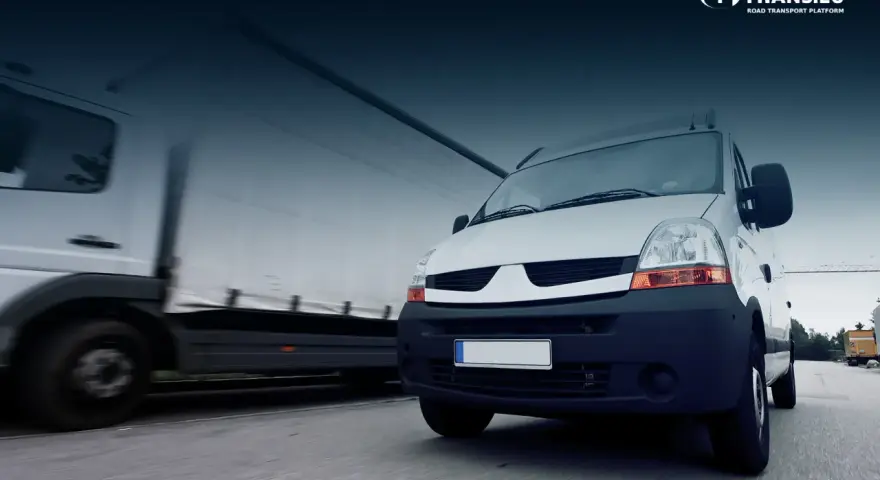 Biały bus i ciężarówka w ruchu drogowym. To obraz idealny dla osób, które chcą rozpocząć pracę z własnym busem i rozwijać swoją firmę transportową.
