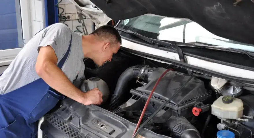 Mechanik bada silnik, szukając przyczyn opóźnionej reakcji na gaz diesel.