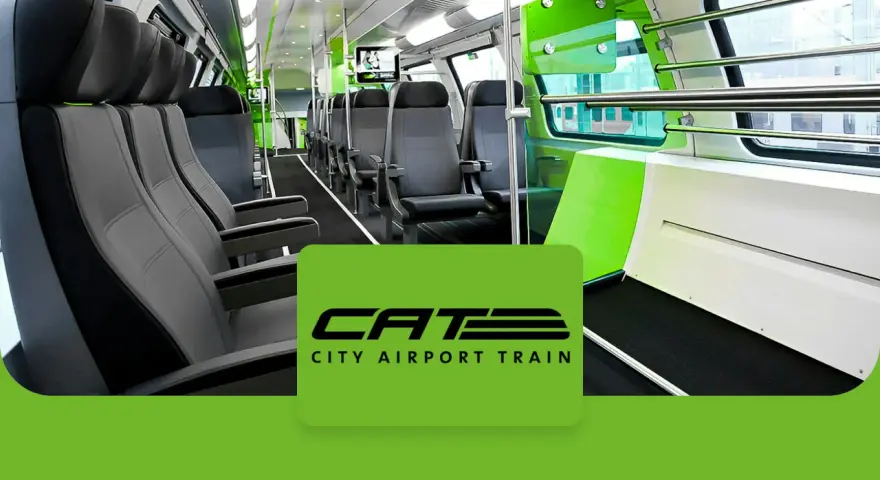 Wnętrze nowoczesnego pociągu CAT, czyli City Airport Train w Wiedniu. Jasne siedzenia i zielone akcenty tworzą przestronną atmosferę.