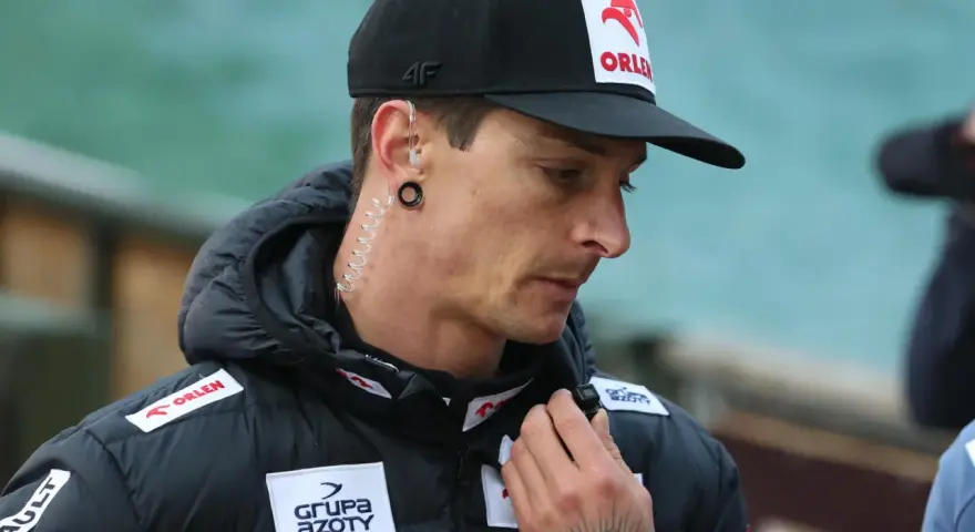 Thomas Thurnbichler, wiek nieznany, w czapce z orłem Orlen i słuchawką w uchu, z tatuażem na dłoni.
