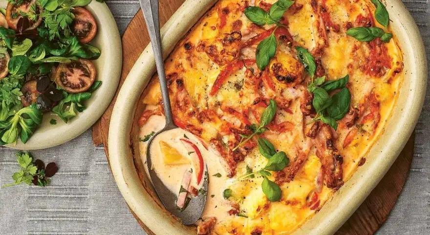 En krämig kasslergratäng med ost och örter, serverad med en fräsch sallad. Ett perfekt kassler recept för middagen.