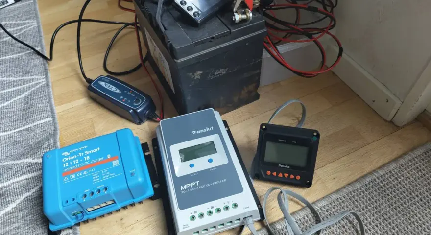 En batteriladdare och solcellsregulatorer kopplade till ett batteri. Var försiktig, ett kokande batteri är farligt.
