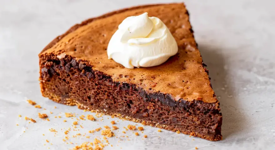 En bit kladdig protein kladdkaka med en klick vispad grädde.