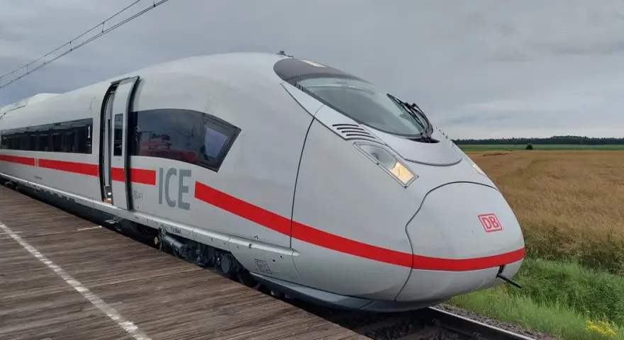 Nowoczesny, biały pociąg ICE 3neo z czerwonym pasem, stojący na peronie.