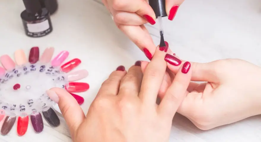 Manicure w czerwonym kolorze, idealny sposób na to, jak zapuścić paznokcie po obgryzaniu. Paleta kolorów lakierów do paznokci.