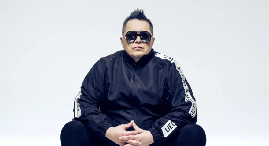 Marek "Mrozu" Mróz w okularach i czarnej kurtce z napisem "GETTA", jakby szykował się na koncert zespołu Munka Staszczyka.