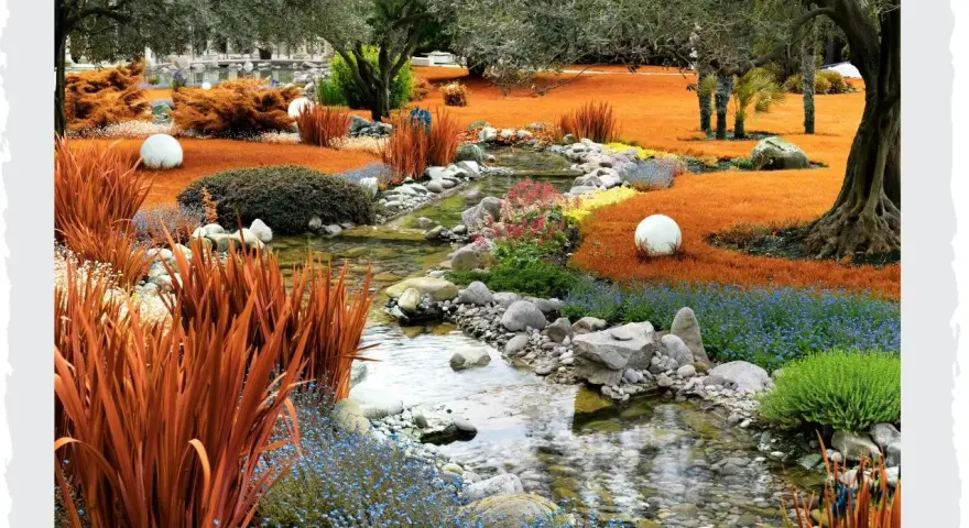 Ein malerischer asiatischer Garten mit einem Bachlauf, orangefarbenem Gras, blauem und gelbem Blütenteppich, Steinen und weißen Kugeln.