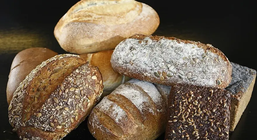 Variedad de panes artesanales, algunos con semillas. ¿Cuál es el pan más sano? Los integrales y con semillas suelen ser la mejor opción.