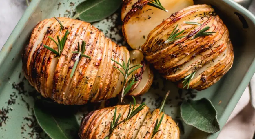 Pommes de terre Hasselback dorées et croustillantes, garnies de romarin frais. Une recette pomme de terre parfaite pour accompagner vos plats.