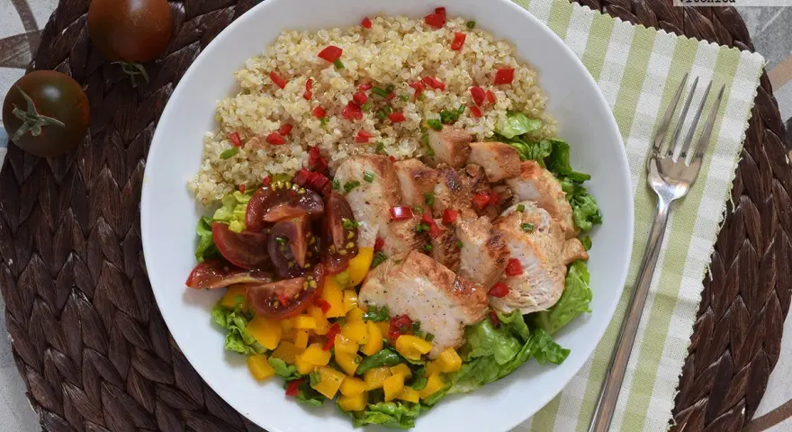 Bowl con quinoa, pollo a la plancha, tomates y mango. Un plato ideal de alimentos saciantes para adelgazar.