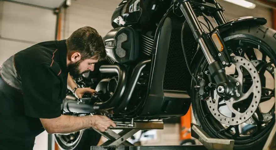 Meccanico al lavoro su una moto. Per sapere i tagliandi Ducati ogni quanti km, consulta il manuale.