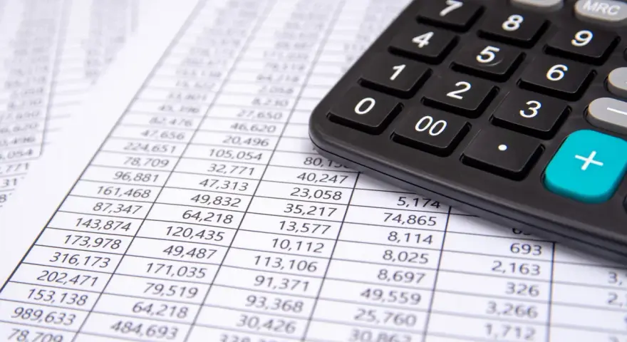 Calculadora sobre hoja de cuentas, mostrando posibles remuneraciones pendientes de pago activo o pasivo.