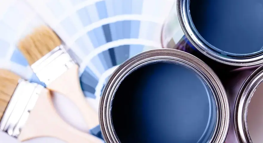 Lattine di vernice blu e pennelli su campioni di colore. Ideale per la vernice per mdf.