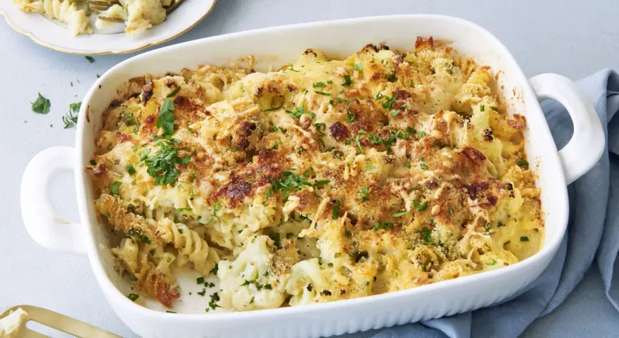 Ein goldbrauner blumenkohl nudel auflauf mit Käse überbacken und frischer Petersilie garniert, bereit zum Servieren.