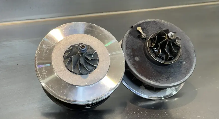 Due turbocompressori per motore, uno nuovo e uno usurato, pronti per un intervento.