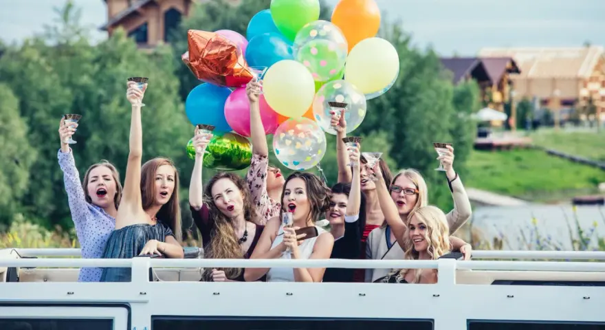 Radosne kobiety z kieliszkami i balonami świętują wieczór panieński. Mnóstwo kolorowych niespodzianek na wieczór panieński!