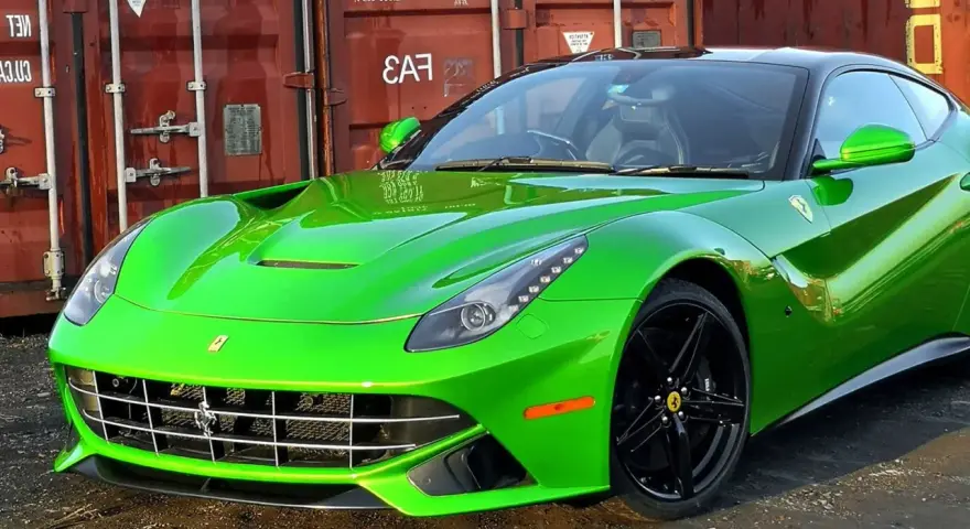 Jaskrawozielone Ferrari F12 Berlinetta z czarnymi felgami, zaparkowane przed czerwonym kontenerem.