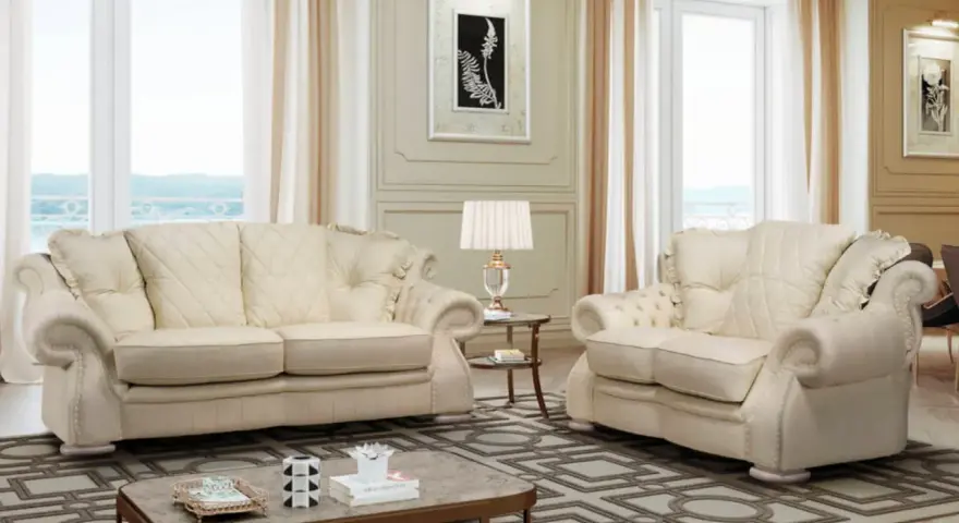 Elegante soggiorno con divani chiari, un tavolino e una lampada. Il tessuto sembra il miglior tessuto per divani antimacchia, ideale per una casa raffinata.
