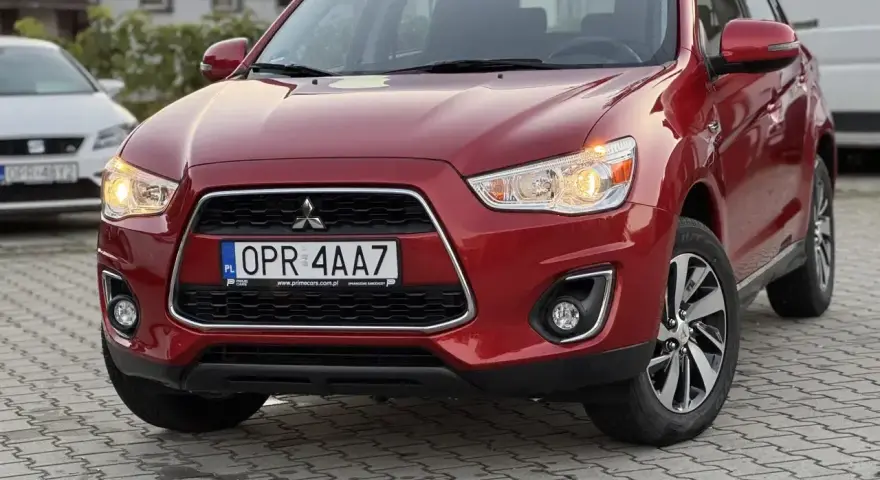 Czerwone Mitsubishi ASX z przodu, z tablicą rejestracyjną OPR 4AA7.