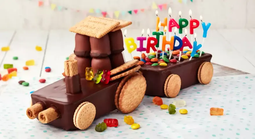 Schokoladen-Traktor-Torte, die man leicht selber machen kann, mit bunten Kerzen und Gummibärchen verziert.