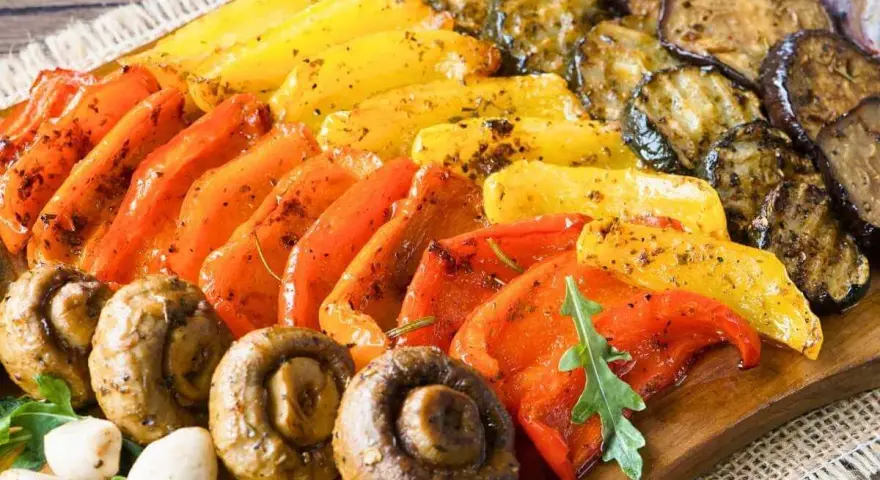 Eine bunte fingerfood antipasti platte mit gegrilltem Gemüse: Paprika, Zucchini, Auberginen und Champignons, appetitlich gewürzt.