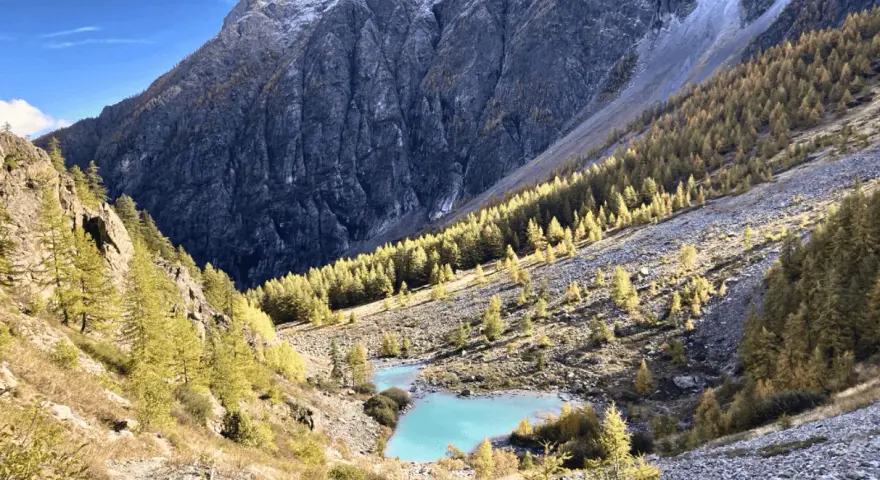 Magnifique lac turquoise au cœur d'une vallée alpine aux couleurs d'automne, parfait pour un tour des Écrins 10 jours.