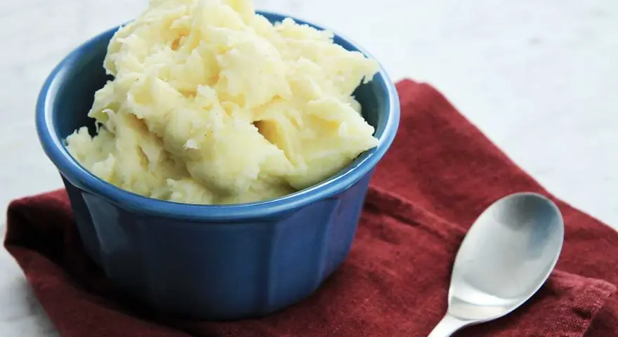 Krämigt potatismos i en blå skål, redo att serveras. Ett enkelt potatismos recept som passar till det mesta.