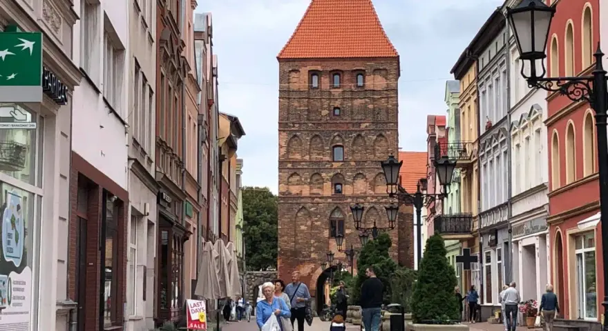Spacer po urokliwej uliczce z kolorowymi kamienicami, prowadzącej do zabytkowej bramy człuchowskiej.