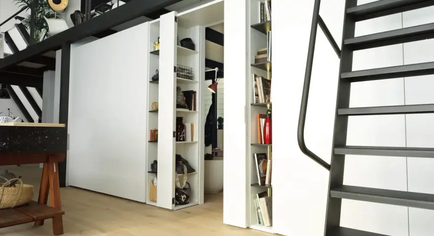 Divisori ambienti interni con librerie a scomparsa, ideali per organizzare e definire spazi in stile moderno.
