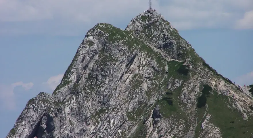 Szczyt Giewontu z krzyżem, pełen turystów. Czy Giewont jest trudny? Trasa wymaga kondycji, ale widoki wynagradzają wysiłek.