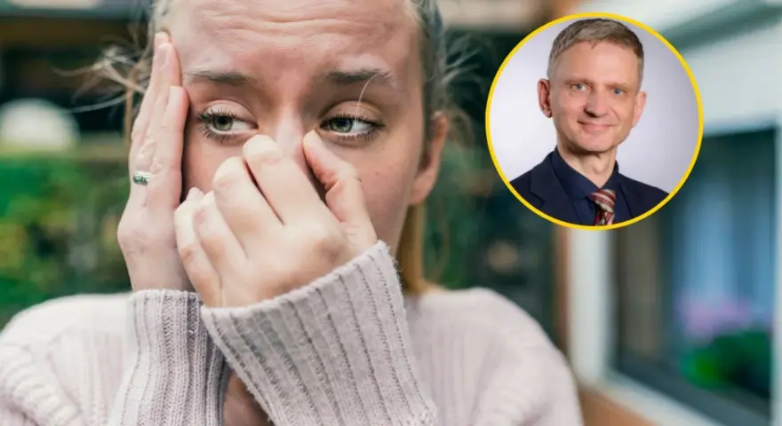 Zmartwiona kobieta z dłońmi na twarzy, jakby walczyła z amnezją. Obok niej uśmiechnięty mężczyzna w garniturze.
