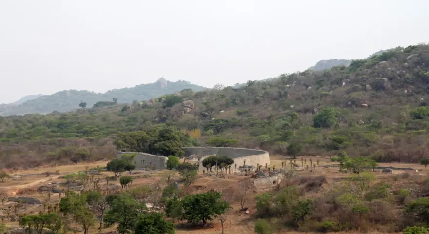 Ruiny Wielkiego Zimbabwe, kamienne mury i pozostałości dawnych budowli w otoczeniu bujnej zieleni i skalistych wzgórz.
