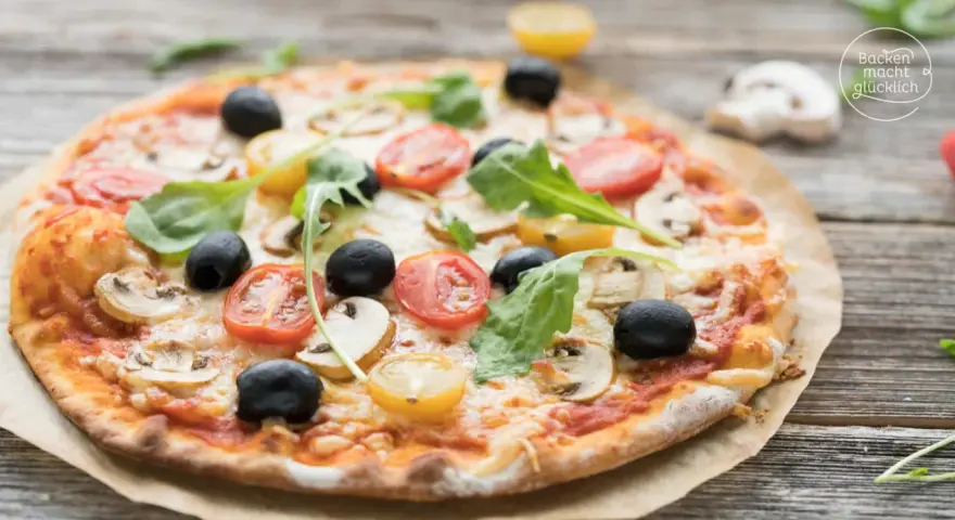 Pizza mit original italienischem pizzateig wenig hefe, belegt mit Tomaten, Oliven und Pilzen.