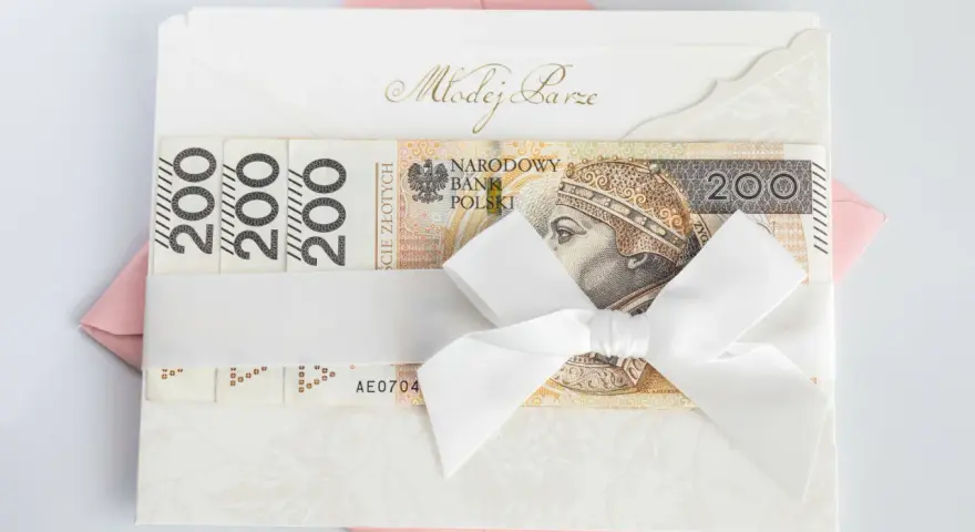 Elegancka koperta z napisem "Młodej Parze", ozdobiona banknotami 200 zł i białą wstążką. Idealny sposób, jak udokumentować pieniądze z wesela.