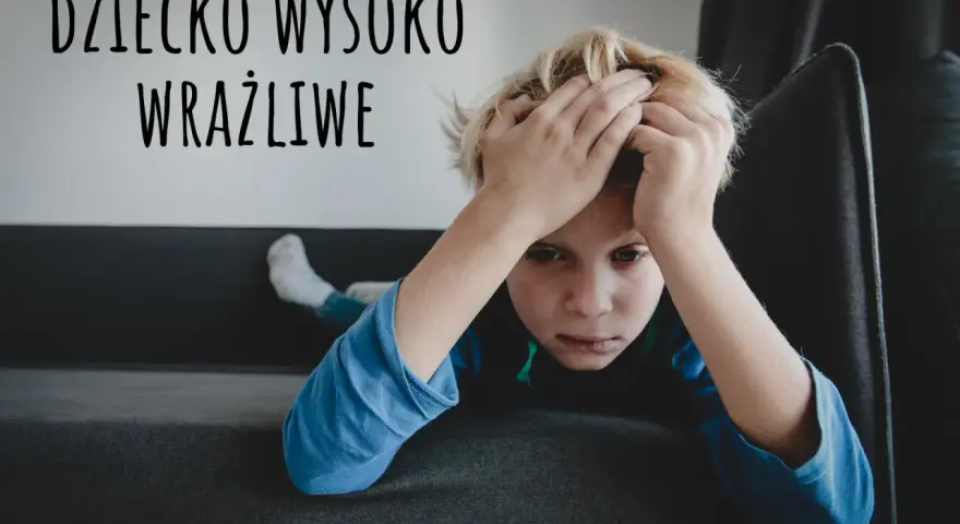 Chłopiec z rękami na głowie, wyrażający smutek. Napis "DZIECKO WYSOKO WRAŻLIWE" sugeruje, że może to być wyraz jego emocji.
