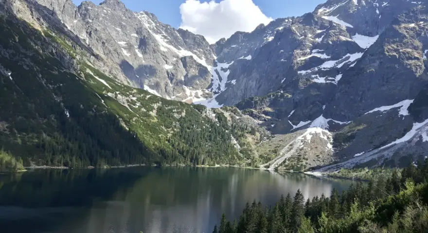 Majestatyczne góry otaczają spokojne Morskie Oko, odbijając w swojej tafli skaliste szczyty i zielone lasy.