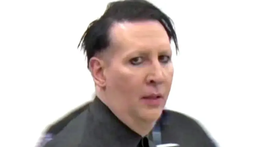 Marilyn Manson bez makijażu, z charakterystycznym makijażem oczu, w czarnej koszuli.