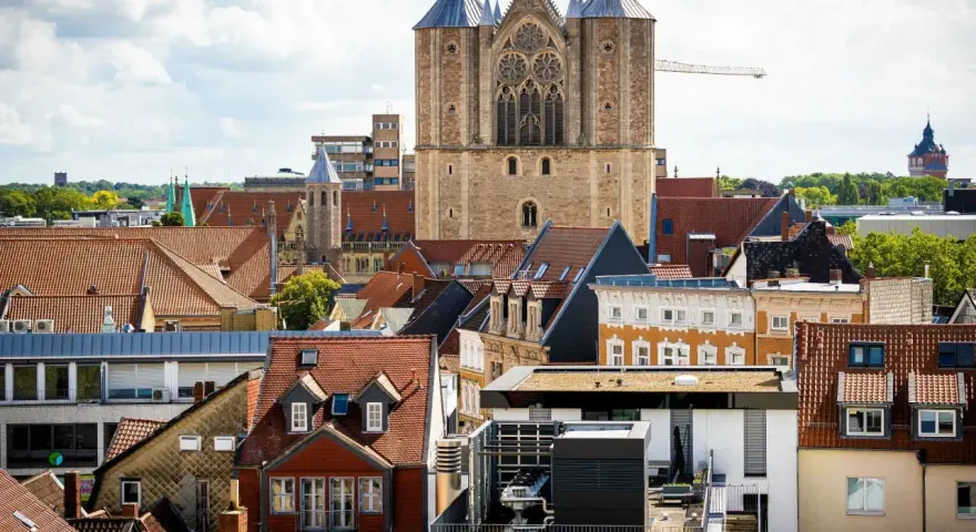 Blick über Dächer auf eine Kirche. Über den Austritt aus der Kirche und steuerliche Folgen wird nachgedacht.