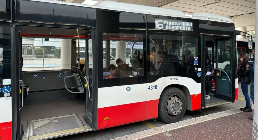 Autobus linii 16 do lotnisko w Bari czeka na pasażerów. W środku siedzą ludzie, drzwi są otwarte.