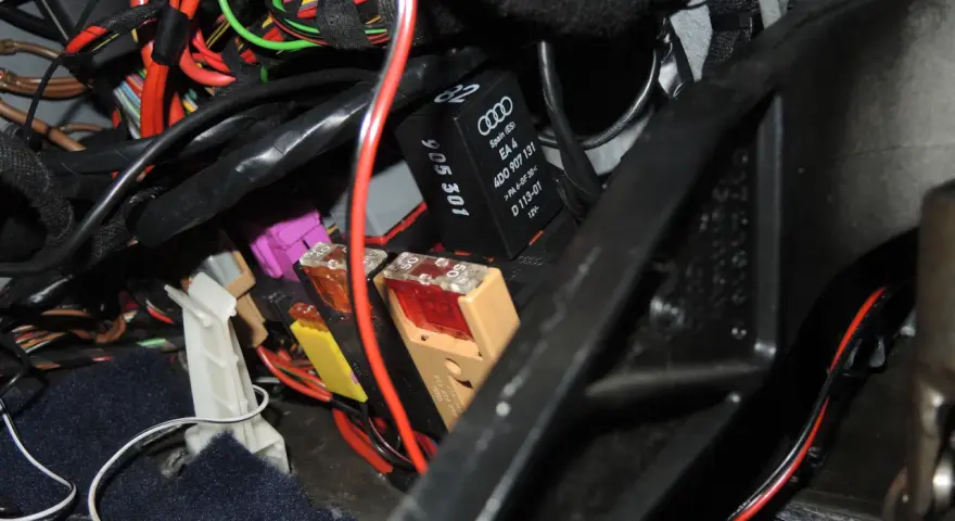 Pompka centralnego zamka Audi A4 B5 znajduje się w wiązce przewodów pod deską rozdzielczą, obok bezpieczników.