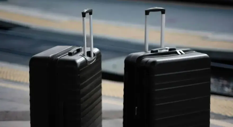 Dwa czarne walizki, idealne jako bagaż podręczny Ryanair, czekają na podróż.