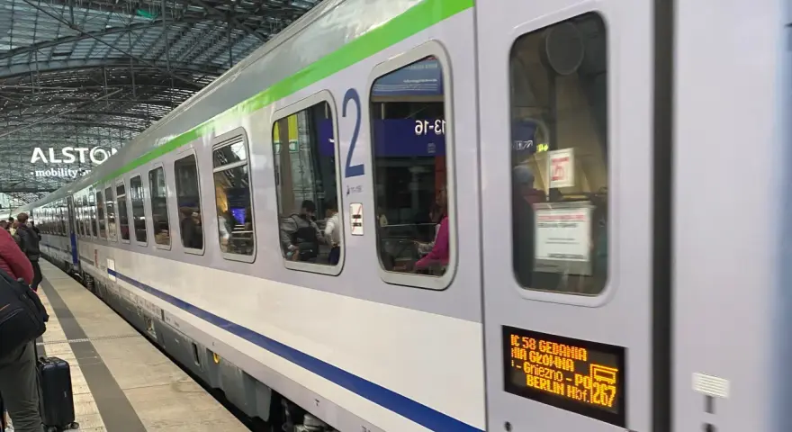 Pociąg IC 58 Gedania z Gniezna do Berlina stoi na peronie. Widać pasażerów w środku.