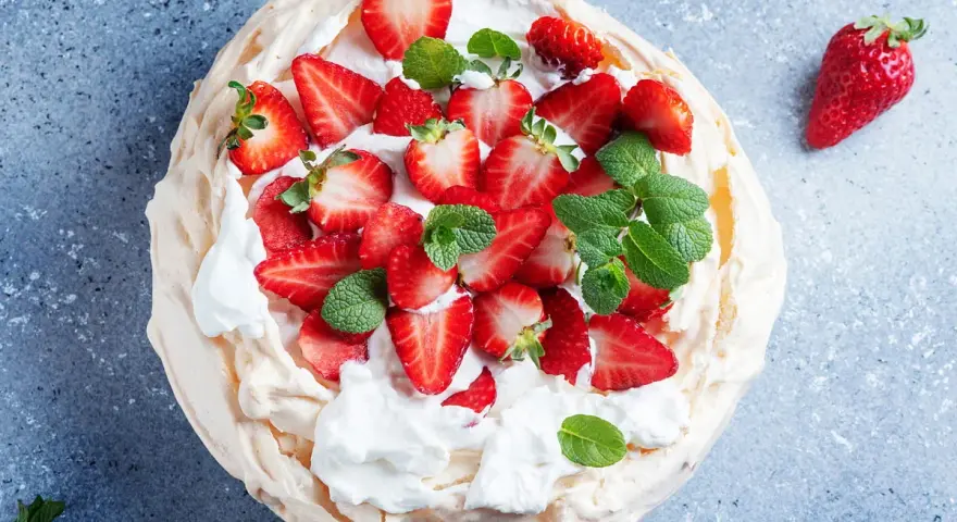 Pyszny deser Pavlova z truskawkami, idealny przepis na bezy z 3 białek. Lekka i chrupiąca beza z bitą śmietaną i owocami.