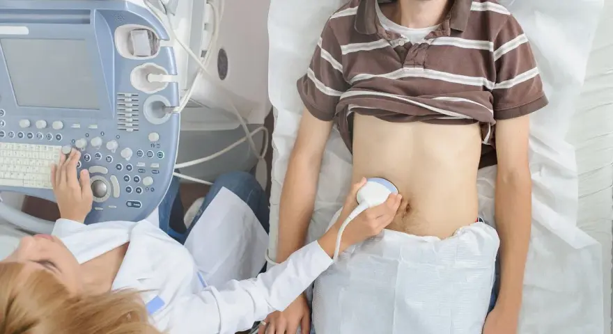 Lekarz wykonuje USG brzucha pacjentowi, szukając przyczyn zapalenia wyrostka sutkowatego i zastanawiając się, jaki antybiotyk będzie najskuteczniejszy.